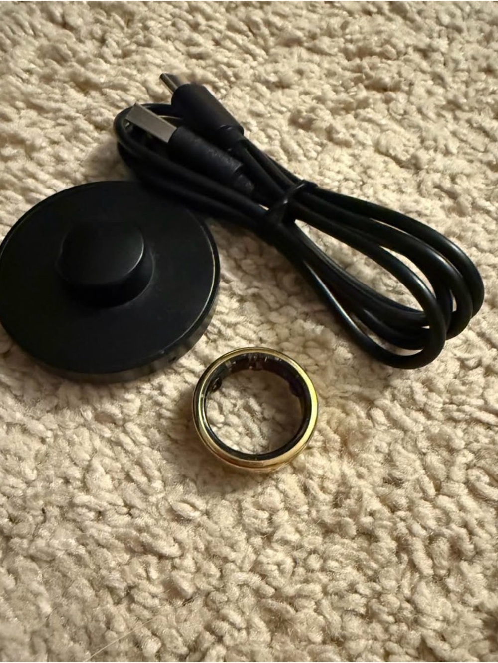 Oura Smart Ring with Gold Finish and Black Charger